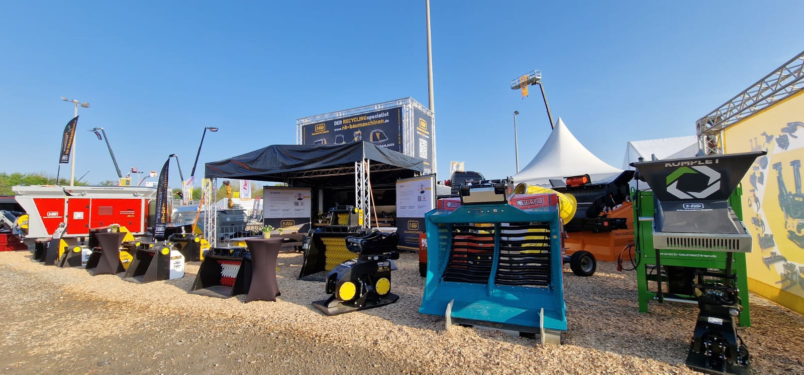Verschiedene maschinen eines standes auf einer baumesse. Mit schaufeln und verschiedenen anbaugeräten